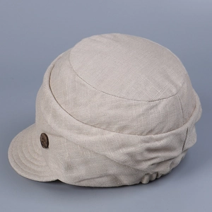 Detail of beige linen duckbill cap showing wooden button and breathable fabric texture