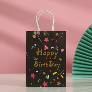 Detail of black paper gift bag with golden Happy Birthday text and colorful balloons
