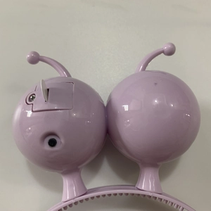 Detail shot of the battery compartment, power switch and safety tab on pink LED headband