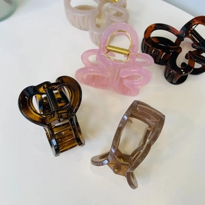 Flat lay of multiple resin butterfly hair claws in amber pink and beige colors