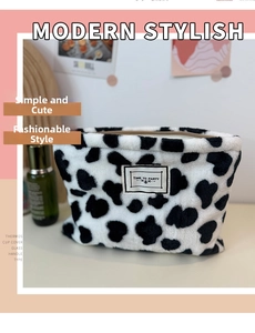 Close-up of cow print plush coin purse featuring a Time to Party label and zipper detail