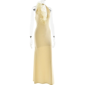 Détail de la robe longue dos nu beige avec élégant motif de fleur à volants au décolleté