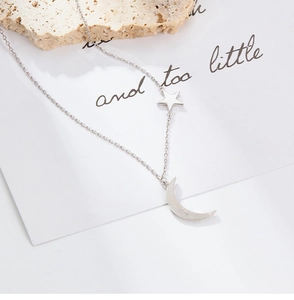 Detailed view of silver star and moon pendant necklace on a natural light yellow stone