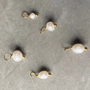 Detailed view of five baroque pearl pendants with gold bails for DIY jewelry making