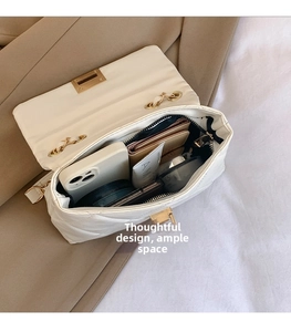 Detail showing the large interior capacity of the white quilted crossbody bag for essentials