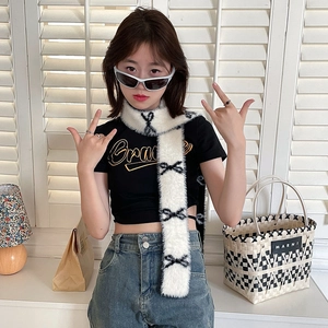 Detail showing plush white winter scarf with black bow patterns on a fashion model