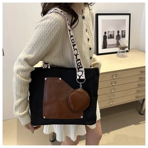 Detail of canvas tote bag with brown leather pocket and round coin purse accessory