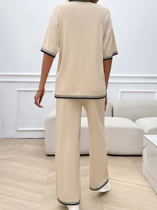 Détail de l'ensemble en tricot abricot avec bordures rayées noires et blanches