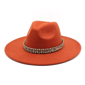 Detail of wide brim rust red wool fedora hat featuring an ethnic woven decorative band