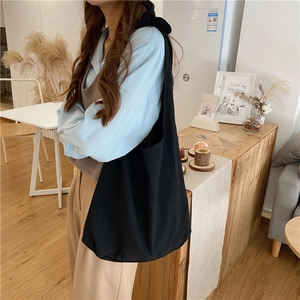 Large black canvas tote bag shown on shoulder for daily commute and student use