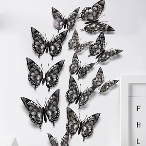 Macro shot of 3D black hollow butterfly wall stickers arranged on a white wall decor