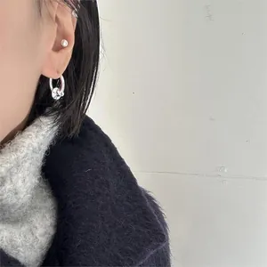 Close-up of minimalist double hoop silver earrings on model with a modern aesthetic