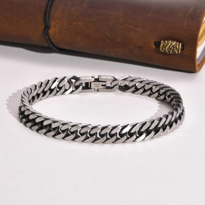 Detail of silver stainless steel Cuban chain bracelet with secure clasp and engraving