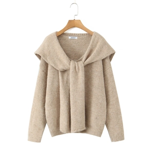 Close-up of beige knit sweater with unique shawl collar and textured cable knit detail