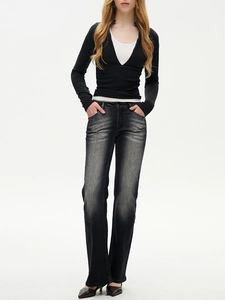 Detailed close-up of dark wash high-waisted flared jeans with a slim black zipper top