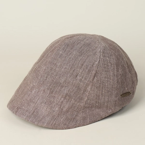 Close-up of brown linen fabric texture and metal logo detail on the breathable flat cap