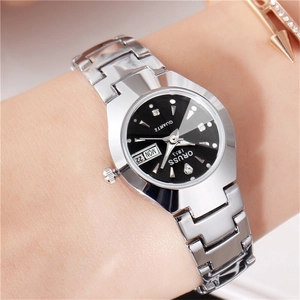 Détail d'une montre en acier argenté avec cadran noir et guichet date-jour au poignet