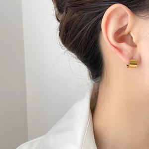 Minimalist gold U-shaped hoop earrings with polished mirror finish on female model