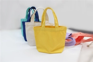 Detailed row of colorful canvas lunch bags in yellow, beige, navy and pastel tones
