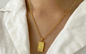 Dettaglio della collana con ciondolo rettangolare a raggi solari placcata in oro 18K