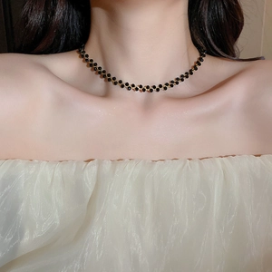 Detail einer schwarzen Kristallperlenkette mit vergoldetem Draht an einem Model
