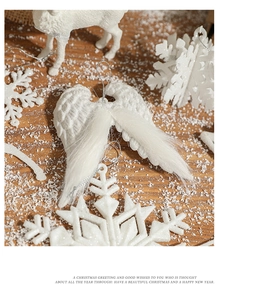 Detailed view of white Christmas tree ornaments with glitter angel wings and snowflakes