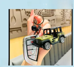 Detail view of a camouflage jeep keychain with a black bell and metal ring accessory