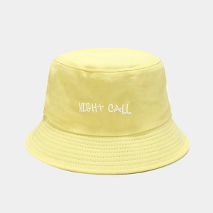 Close-up of yellow cotton bucket hat featuring white Night Call letter embroidery