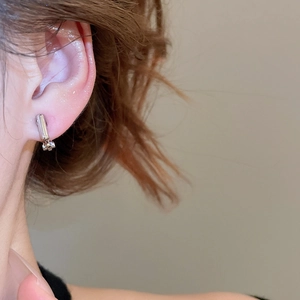 Close-up of geometric silver ear clip converter on ear showing a sleek minimalist design