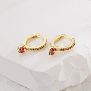 18K gold plated copper earrings with red zircon heart pendants on white stone