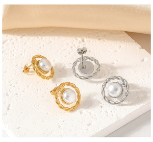 Detail of twisted metal stud earrings with center white pearl in gold and silver finish