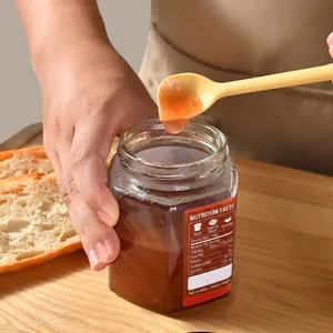 Espátula de silicona para mermelada extrayendo conserva de fruta de un bote de cristal