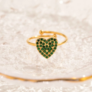 Vista macro di anello a cuore regolabile placcato oro 18K con zirconi verdi pavé