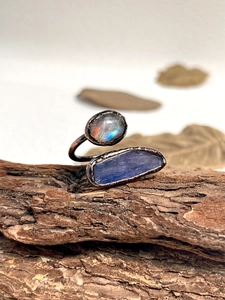 Macro view of handmade retro ring featuring raw labradorite and kyanite on wood texture