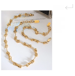 Detail of gold chain necklace with lobster clasp and Lucky tag on a magazine background