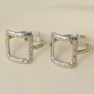 Detailed macro view of two silver adjustable rings with square hammered texture finish