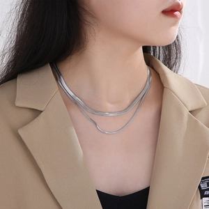 Close-up of double-layered silver snake chain necklace on professional model neck