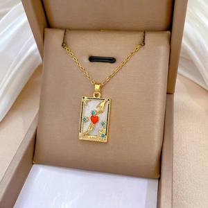 Vintage gold tarot card necklace featuring THE LOVERS pendant with red enamel heart