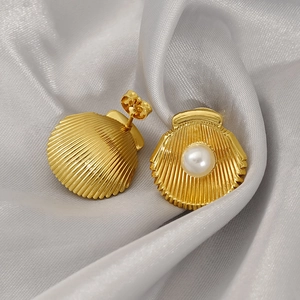 Boucles d'oreilles perles en forme de coquillage dorées 18 carats sur satin gris