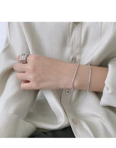 Close-up of minimalist S925 sterling silver layered bracelets on a woman's wrist