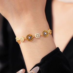 Wrist-worn view of gold chain bracelet with round tiger eye and blue zircon charms