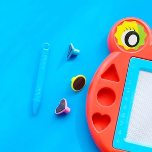 Red owl magnetic drawing board for kids with colorful stamps and stylus on blue background
