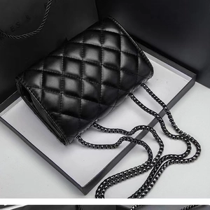 Classic black quilted crossbody bag with metal chain strap and elegant box display