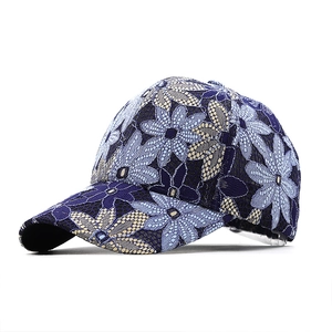 Detailed view of floral lace embroidery on dark blue breathable baseball cap fabric
