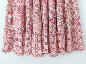 Detail of tiered ruffled hem with red and white floral prints on lightweight fabric