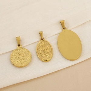 Three vintage gold stainless steel religious portrait pendants and Miraculous Medal on fabric