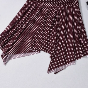 Close-up of dark red polka dot mini skirt with irregular hem and chiffon texture