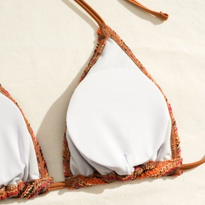 Detail view of striped triangle bikini top featuring bohemian woven edges and inner padding