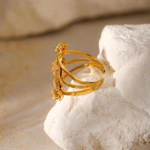 Bague irrégulière en acier inoxydable doré avec zircons sur roche blanche