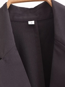 Detail of the blazer dress neckline showing black twill fabric and size S label